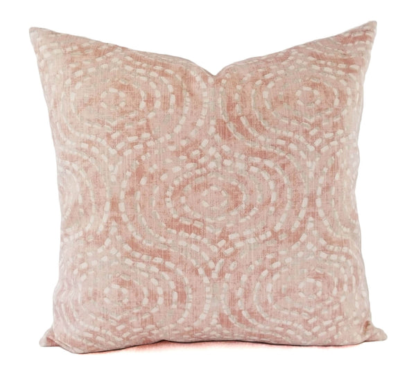 A blush pink pillow with a large trellis pattern.