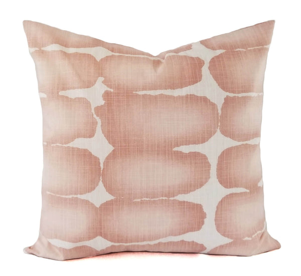 A white pillow with large blush pink oval shapes.