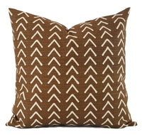 A caramel brown pillow with cream arrow prints.