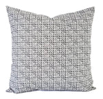 A grey and white pillow in a small polka dot pattern print.