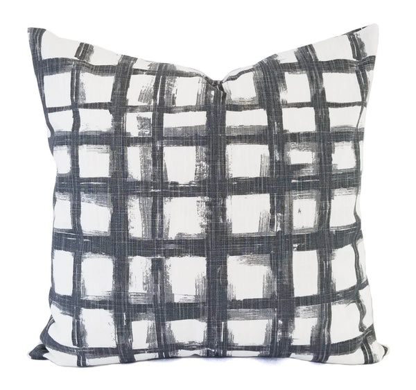 A slate grey and white pillow with a bold checked pattern.