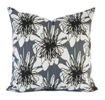 A grey and black pillow with a large scribbled flower pattern.