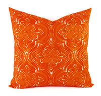 An orange and white damask pillow.