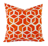 An orange and white pillow in a geometric hexagon print.