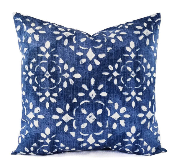 A blue and white pillow with a floral print.