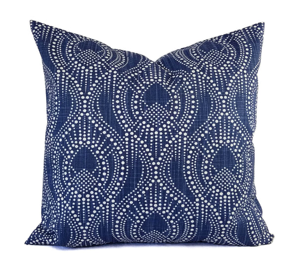 A navy blue pillow with a white geometric trellis pattern.