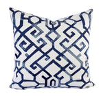 A white pillow with a blue geometric trellis pattern.