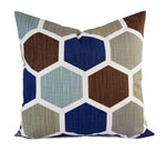 A pillow with a bold blue, brown, taupe, and soft blue hexagon pattern.