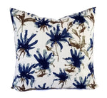 A white pillow with a large blue and brown abstract floral print.
