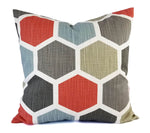 A pillow with a red, grey, and soft blue hexagon pattern.